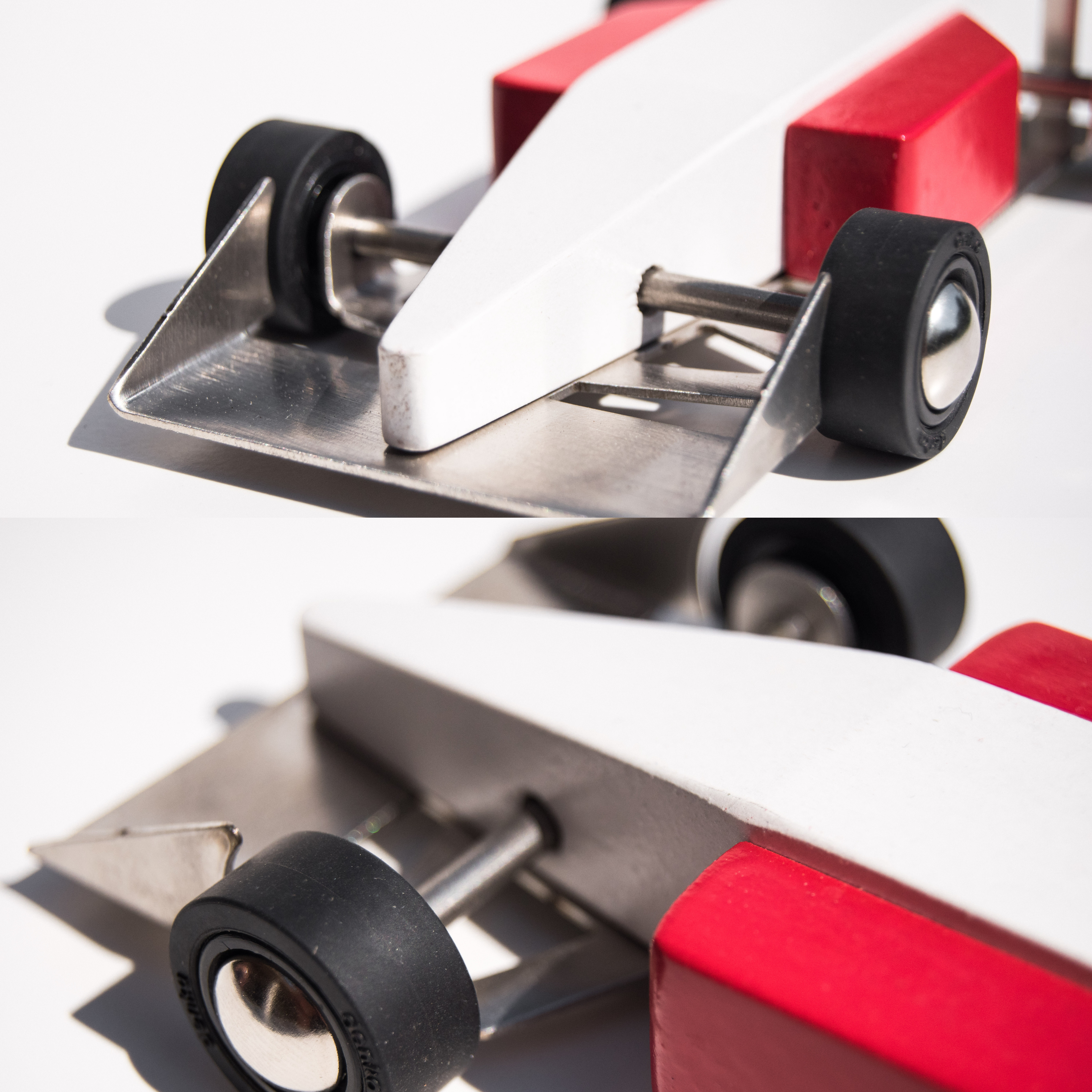 Close-up of a small model car with red and white body and black wheels on a white background.