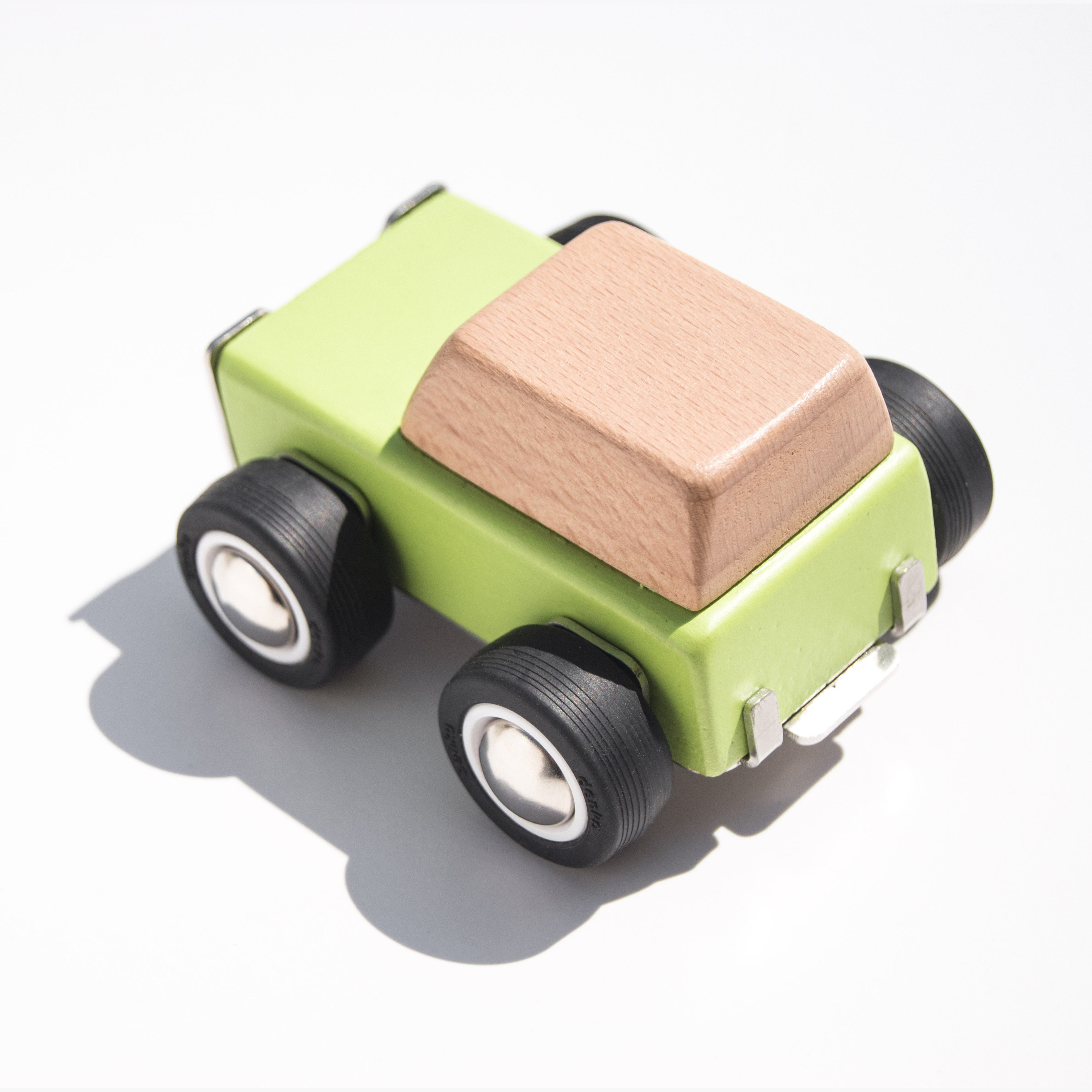 green wooden Toy car with a green body, brown roof, and black wheels on a white background