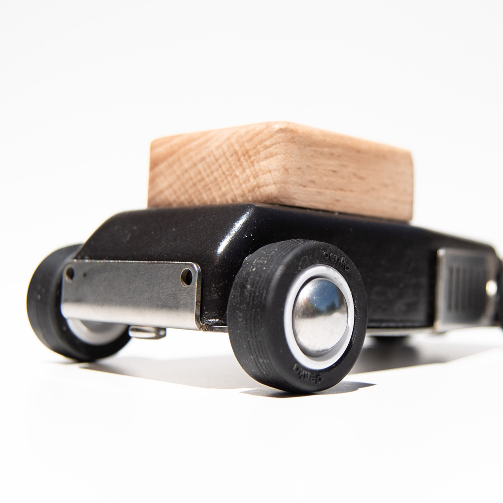 Close-up of a skateboard truck with a wooden deck on a white background