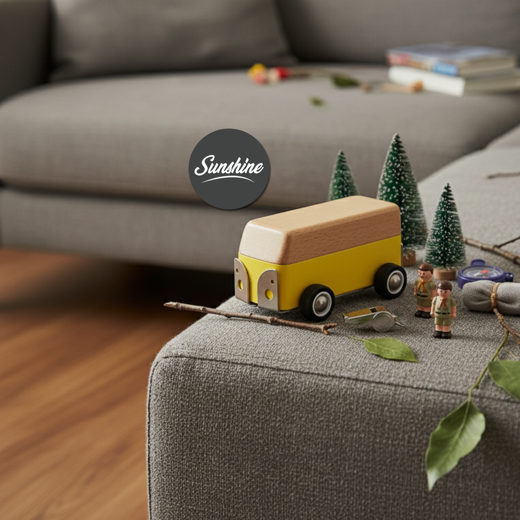Wooden toy bus on a gray surface with decorative elements in a cozy indoor setting.