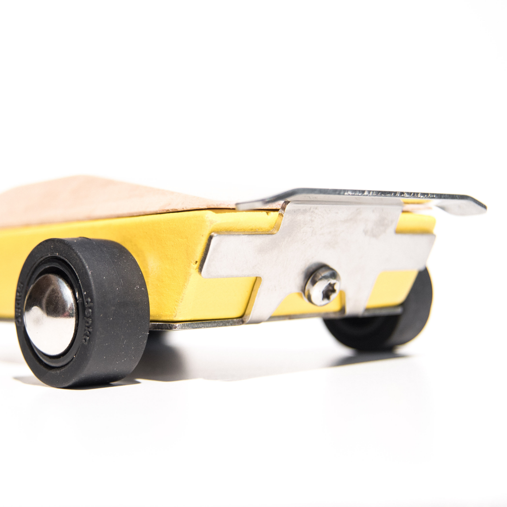 Close-up of a yellow wooden toy car with black wheels on a white background