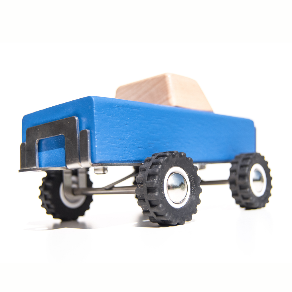 Blue toy truck with a wooden block on a white background
