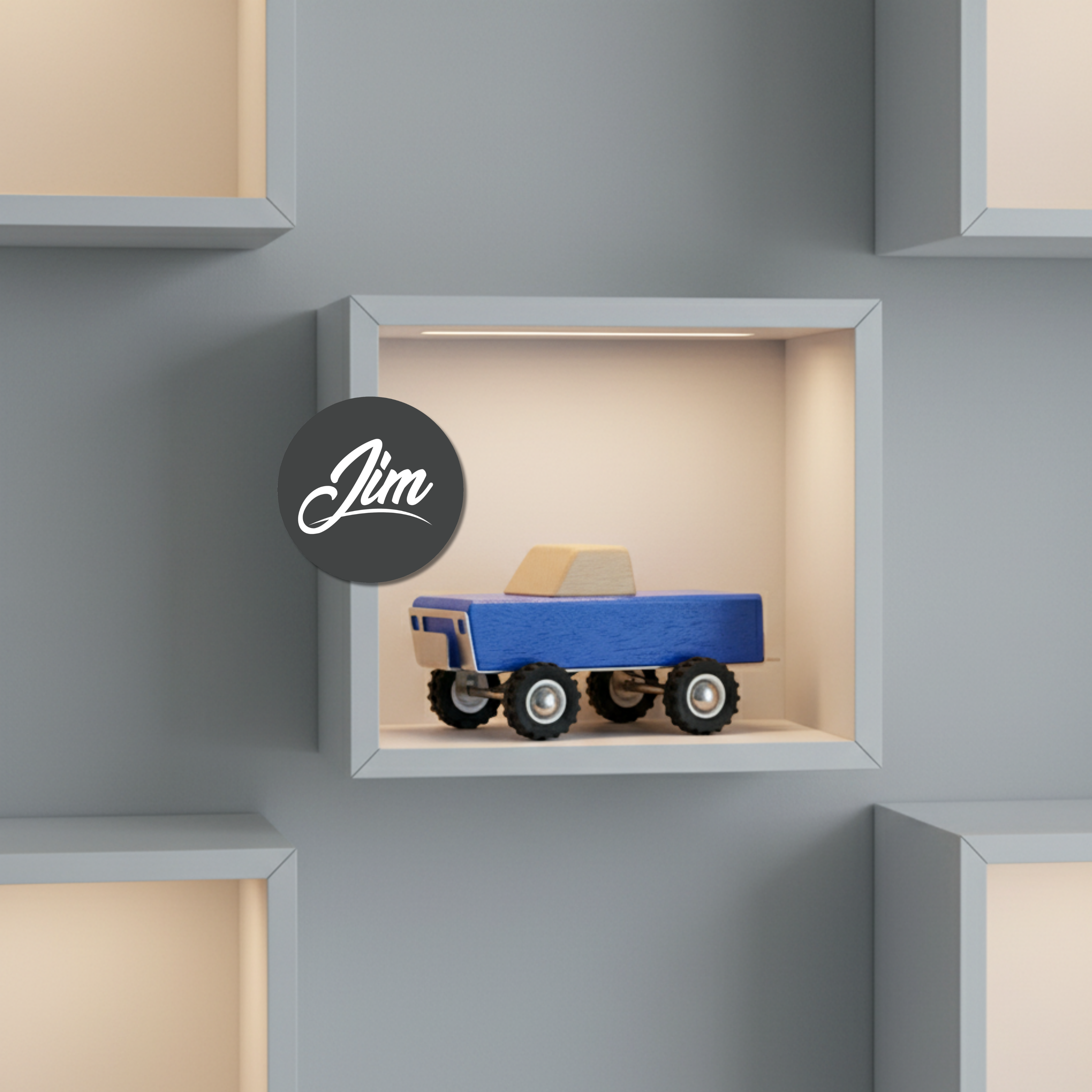 Toy truck in a display box with 'Jim' logo on a gray wall.