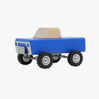 Blue wooden toy truck with a beige bed on a white background