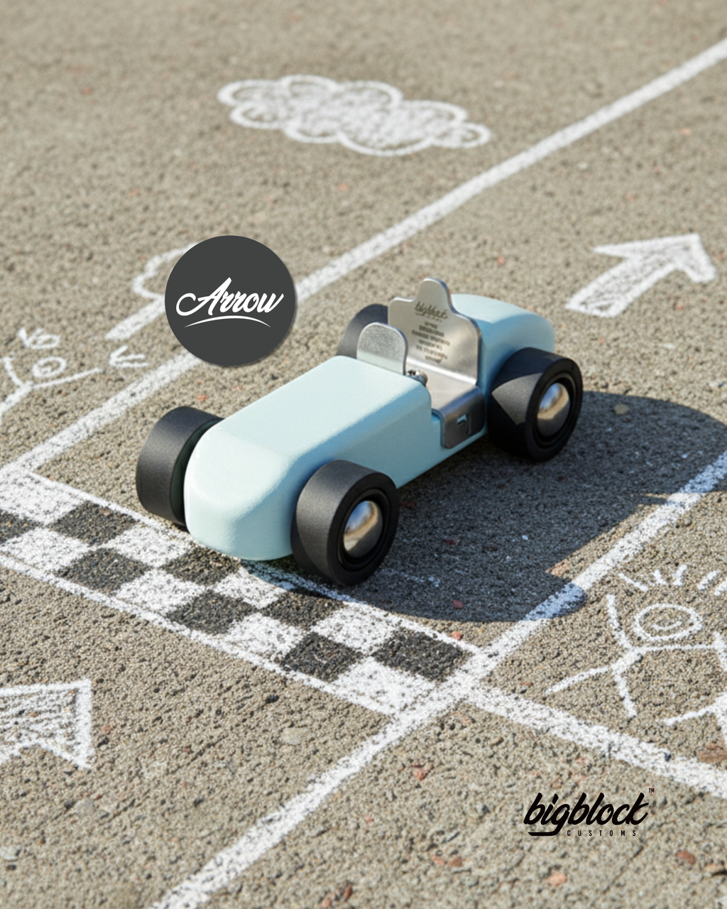 Toy car on a chalk-drawn track with 'Arrow' and 'bigblock' branding.
