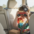 Child playing with a toy car inside a vehicle, with 'bigblock' branding visible.