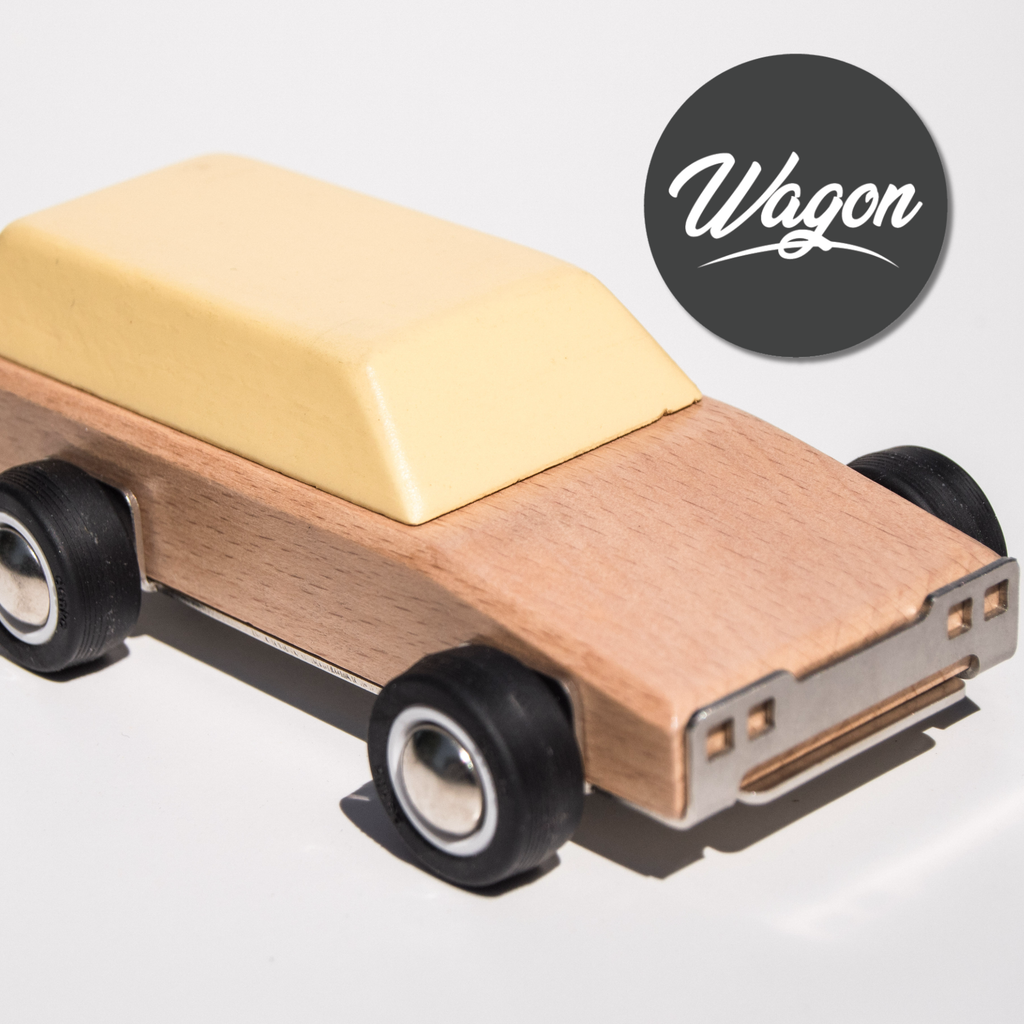 Wooden toy wagon with a beige top and black wheels on a light gray background.
