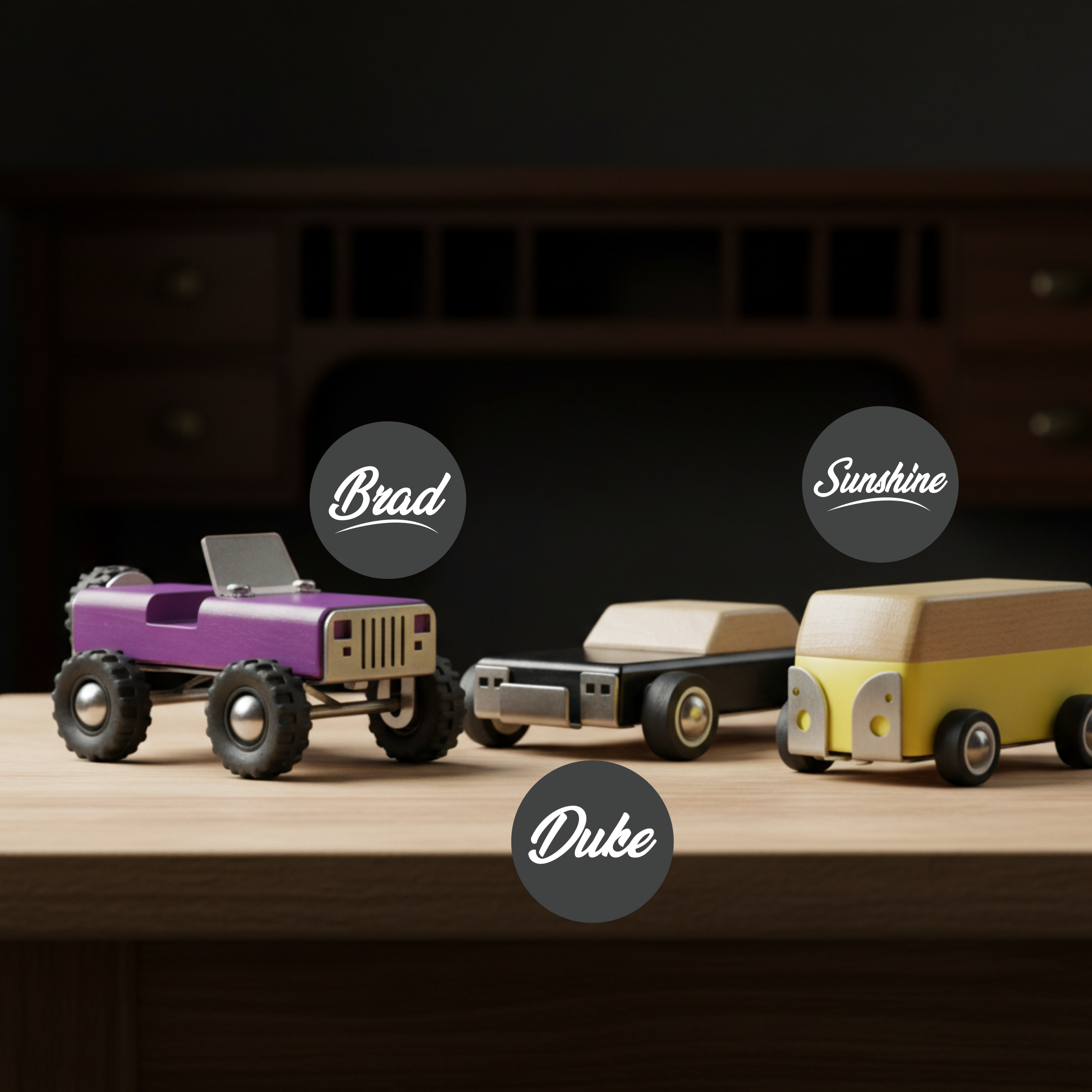 Three toy cars labeled 'Brad', 'Sunshine', and 'Duke' on a wooden surface with a dark background.