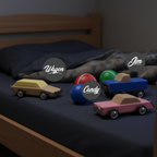 Colorful toy cars labeled 'Wagon', 'Candy', and 'Jim' on a bed.
