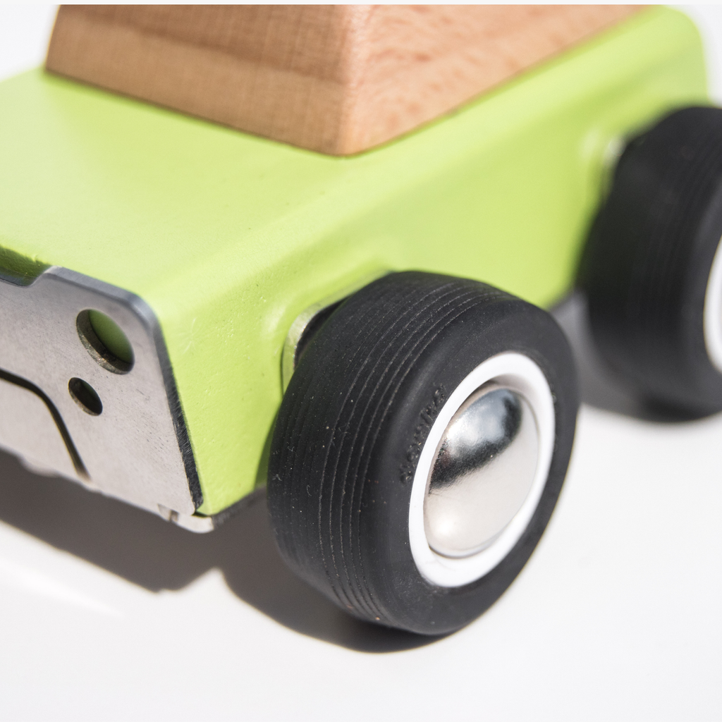 Close-up of a green wooden toy car with black wheels on a white background